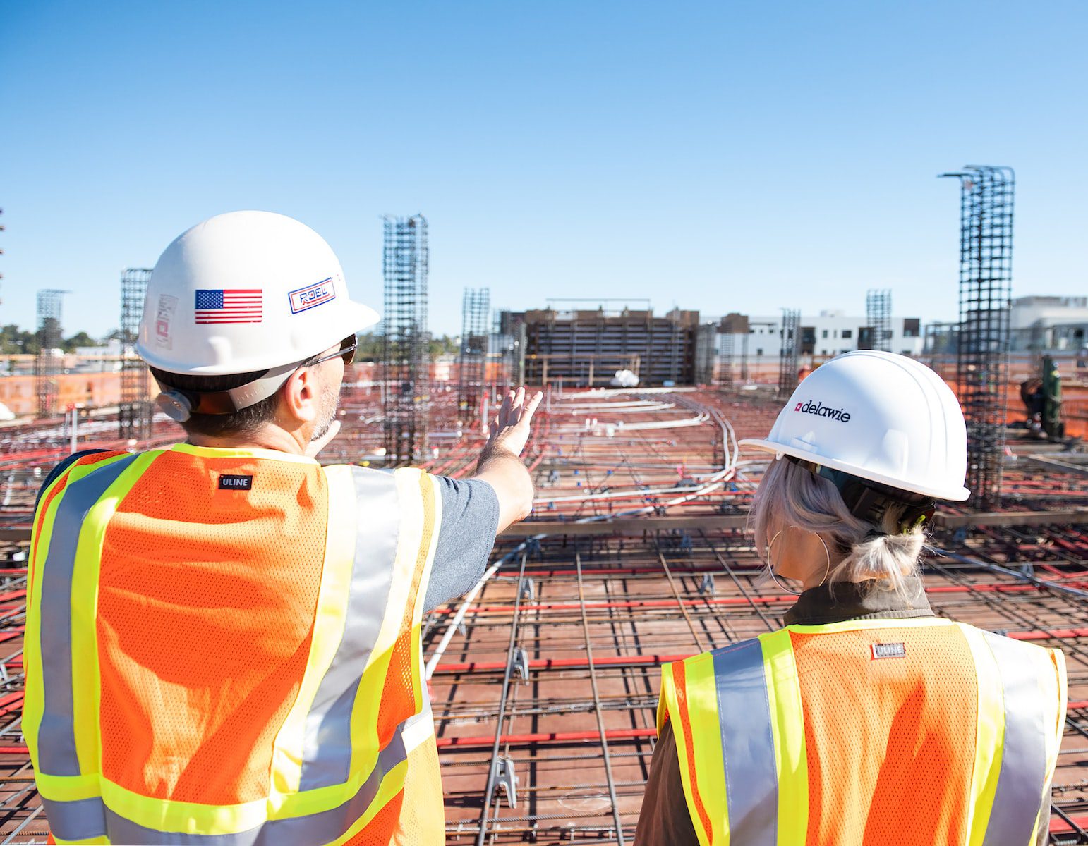 Photo by Joe Holland man in white hard hat standing on brown wooden dock during daytime